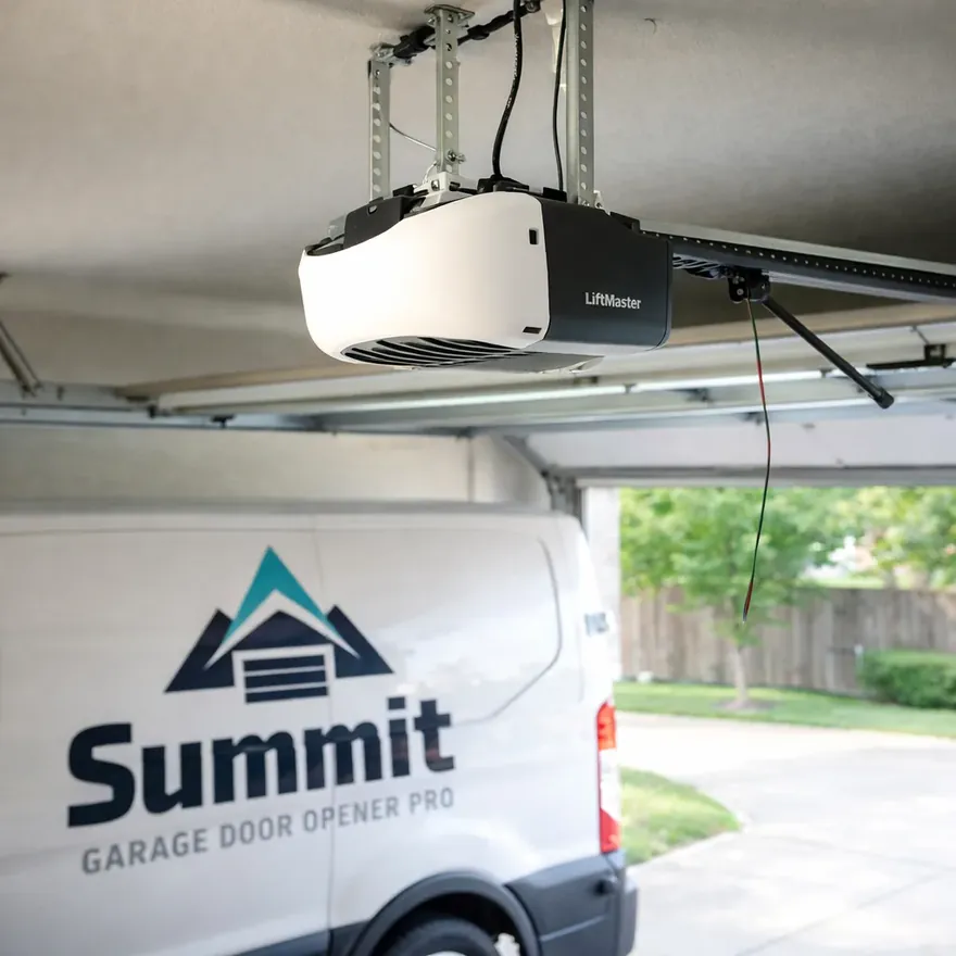 A newly installed belt-drive garage door opener mounted on the ceiling rail of a North Dallas home garage, wiring tidy and complete.