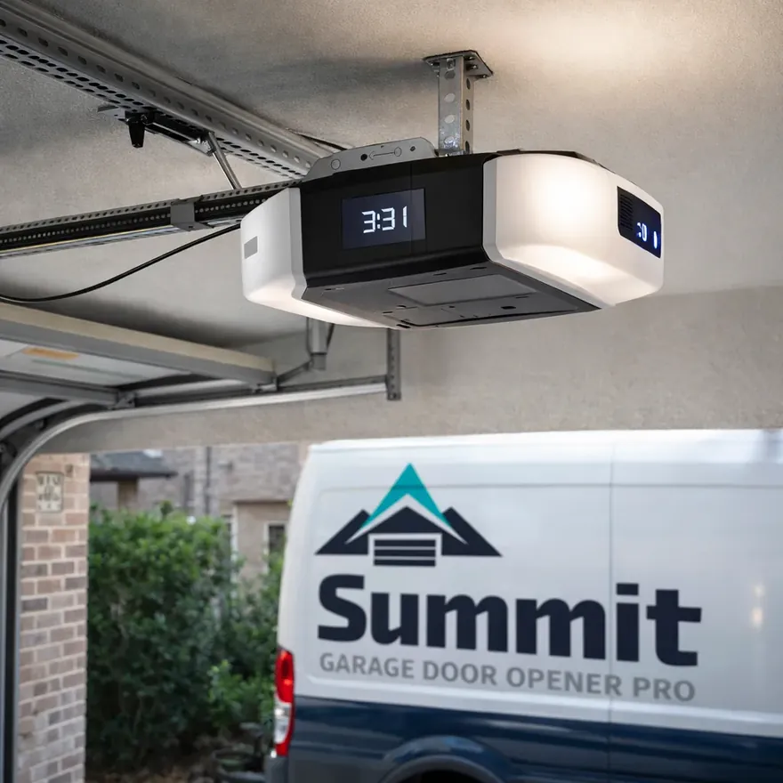 A newly installed smart garage door opener mounted on the ceiling of a residential garage, wiring and rail neatly finished.